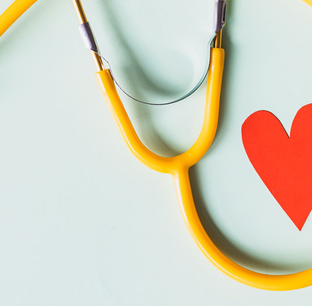 Photo of a stethoscope next to a paper heart