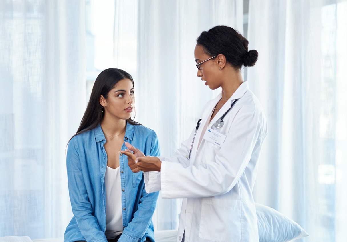 A patient and a doctor having a conversation in a hospital setting.