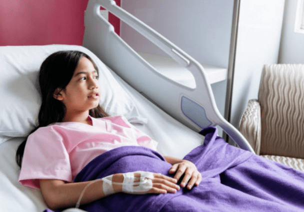 Young female patient lying in a hospital bed looking into the distance.